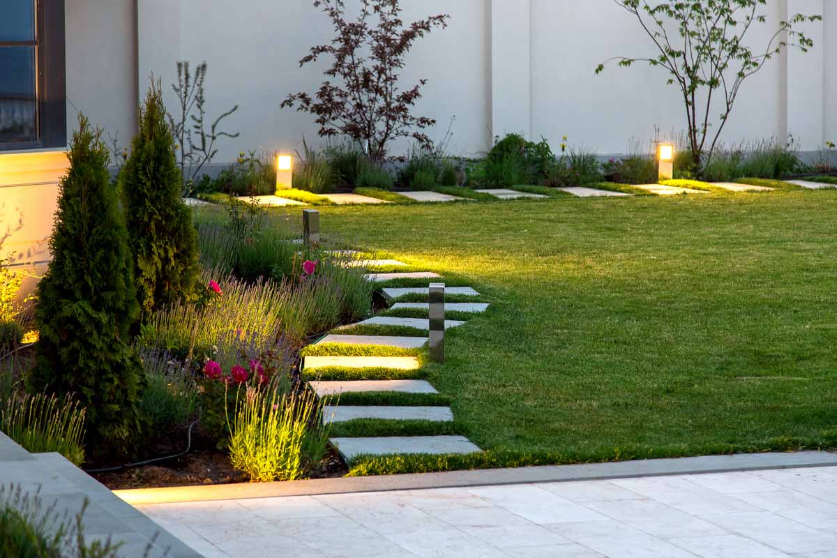 Outdoor lighting adorns a landscaped path through a yard thanks to Hot Shot's services.