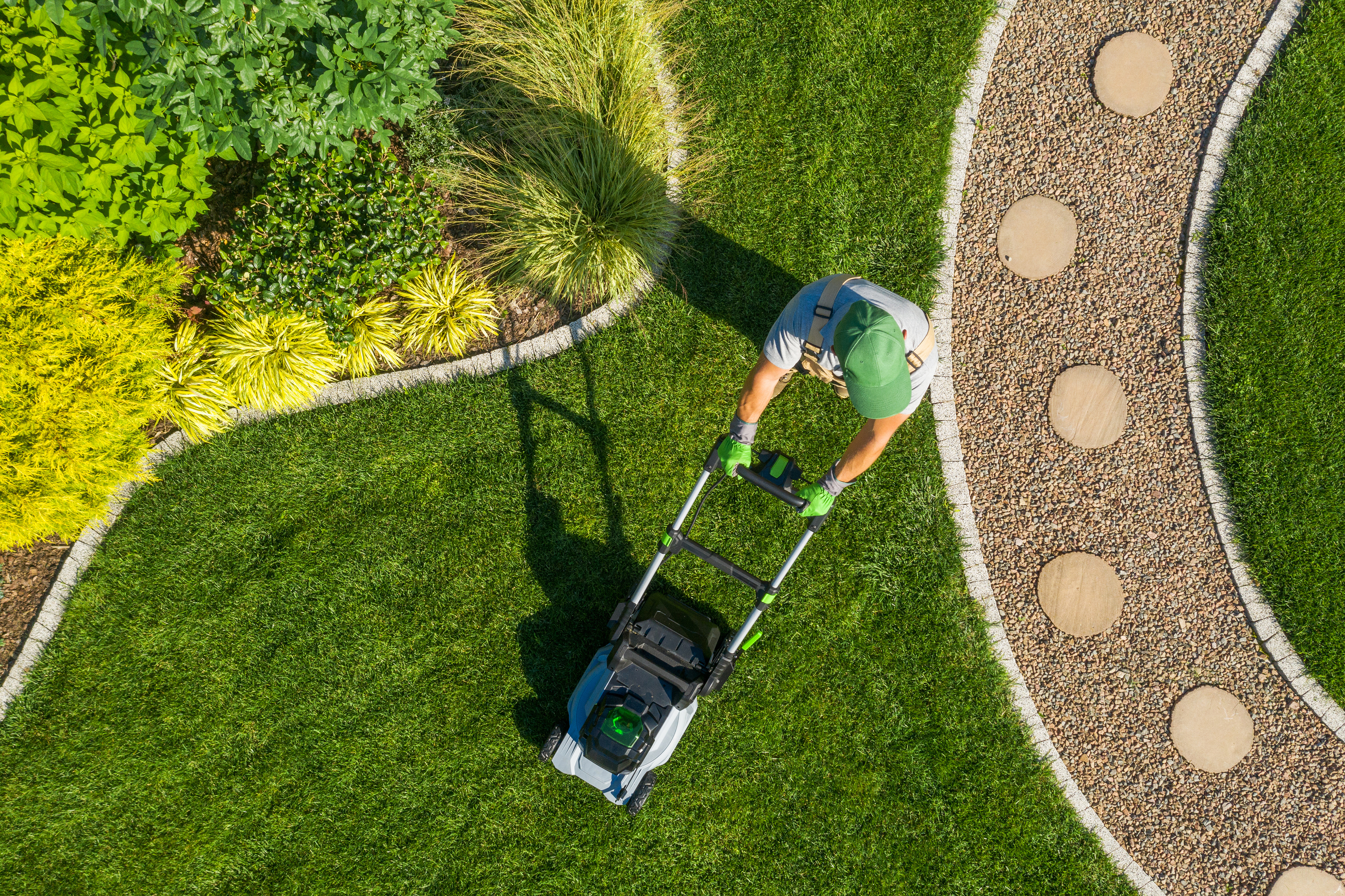 A Hot Shot professional cutting the yard with a mower in Farmington, UT.
