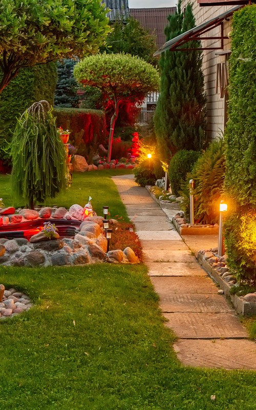 A beautiful lit yard during dusk, provided by Hot Shot Sprinkler Repair & Landscape a landscaping company in Utah.