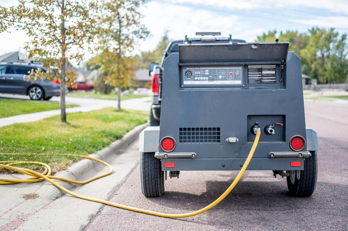 A work truck at a residential home starting the Utah sprinkler winterization process.